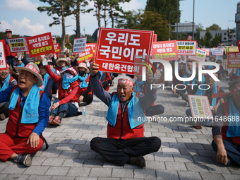 Attendees of a protest organized by around 200 members of the Korea Dog Meat Association and the Korea Dog Meat Sellers' Association hold pl...