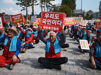 Attendees of a protest organized by around 200 members of the Korea Dog Meat Association and the Korea Dog Meat Sellers' Association hold pl...