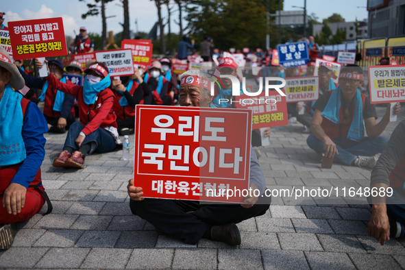 Attendees of a protest organized by around 200 members of the Korea Dog Meat Association and the Korea Dog Meat Sellers' Association hold pl...