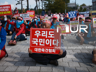 Attendees of a protest organized by around 200 members of the Korea Dog Meat Association and the Korea Dog Meat Sellers' Association hold pl...