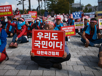 Attendees of a protest organized by around 200 members of the Korea Dog Meat Association and the Korea Dog Meat Sellers' Association hold pl...