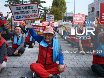 Attendees of a protest organized by around 200 members of the Korea Dog Meat Association and the Korea Dog Meat Sellers' Association hold pl...