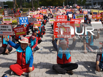 Attendees of a protest organized by around 200 members of the Korea Dog Meat Association and the Korea Dog Meat Sellers' Association hold pl...