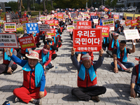 Attendees of a protest organized by around 200 members of the Korea Dog Meat Association and the Korea Dog Meat Sellers' Association hold pl...