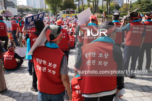 Attendees of a protest organized by around 200 members of the Korea Dog Meat Association and the Korea Dog Meat Sellers' Association hold pl...