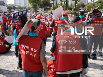 Attendees of a protest organized by around 200 members of the Korea Dog Meat Association and the Korea Dog Meat Sellers' Association hold pl...