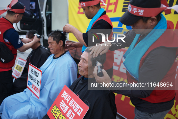 Attendees of a protest organized by the Korea Dog Meat Association and the Korea Dog Meat Sellers' Association shave their heads in front of...