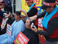 Attendees of a protest organized by the Korea Dog Meat Association and the Korea Dog Meat Sellers' Association shave their heads in front of...