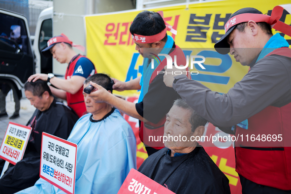 Attendees of a protest organized by the Korea Dog Meat Association and the Korea Dog Meat Sellers' Association shave their heads in front of...