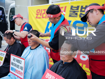 Attendees of a protest organized by the Korea Dog Meat Association and the Korea Dog Meat Sellers' Association shave their heads in front of...