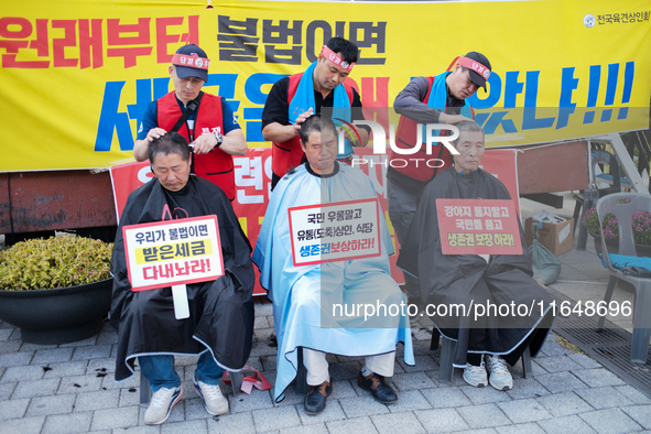 Attendees of a protest organized by the Korea Dog Meat Association and the Korea Dog Meat Sellers' Association shave their heads in front of...