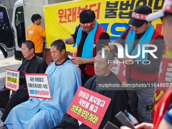 Attendees of a protest organized by the Korea Dog Meat Association and the Korea Dog Meat Sellers' Association shave their heads in front of...