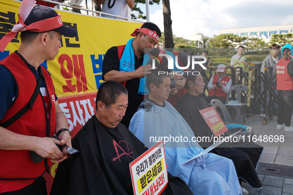 Attendees of a protest organized by the Korea Dog Meat Association and the Korea Dog Meat Sellers' Association shave their heads in front of...