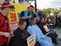 Attendees of a protest organized by the Korea Dog Meat Association and the Korea Dog Meat Sellers' Association shave their heads in front of...