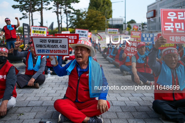 Attendees of a protest organized by around 200 members of the Korea Dog Meat Association and the Korea Dog Meat Sellers' Association hold pl...