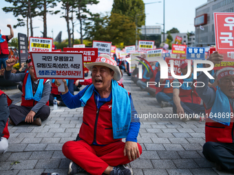 Attendees of a protest organized by around 200 members of the Korea Dog Meat Association and the Korea Dog Meat Sellers' Association hold pl...