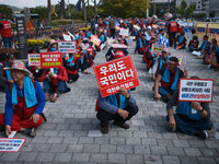 Attendees of a protest organized by around 200 members of the Korea Dog Meat Association and the Korea Dog Meat Sellers' Association hold pl...