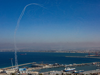 The Israeli military fires Iron Dome missiles to intercept dozens of rockets launched from Lebanon at the northern port city of Haifa, in Is...