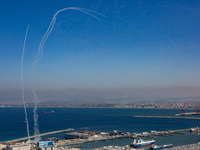 The Israeli military fires Iron Dome missiles to intercept dozens of rockets launched from Lebanon at the northern port city of Haifa, in Is...