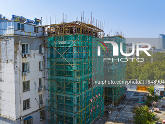 Workers install elevators for multi-storey buildings at the renovation site of an old residential area in Suqian, Jiangsu province, China, o...