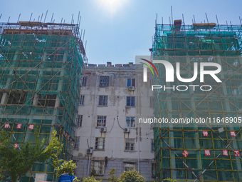 Workers install elevators for multi-storey buildings at the renovation site of an old residential area in Suqian, Jiangsu province, China, o...