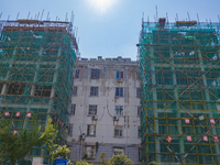 Workers install elevators for multi-storey buildings at the renovation site of an old residential area in Suqian, Jiangsu province, China, o...