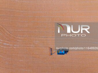 A farmer dries corn in Liaocheng, China, on October 8, 2024. (