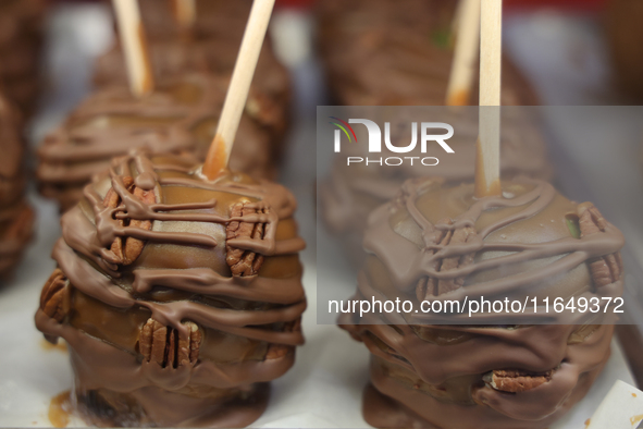 Caramel candy apples are covered with chocolate and pecans at a carnival in Markham, Ontario, Canada, on October 5, 2024. 