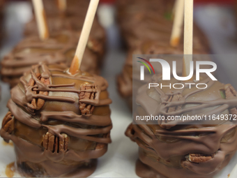 Caramel candy apples are covered with chocolate and pecans at a carnival in Markham, Ontario, Canada, on October 5, 2024. (