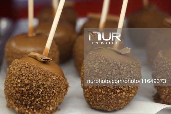 Caramel candy apples are covered with chocolate and sugar at a carnival in Markham, Ontario, Canada, on October 5, 2024. 