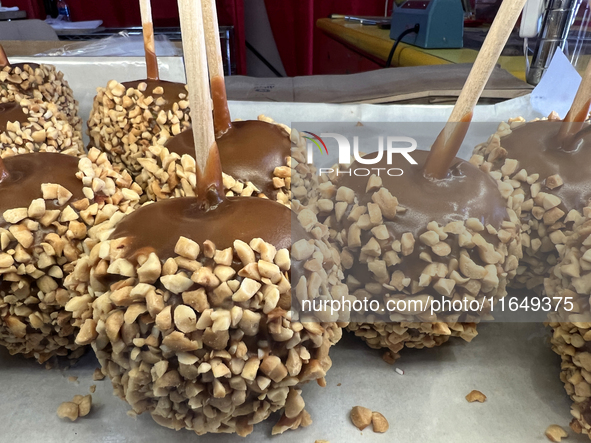 Caramel candy apples are covered with nuts at a carnival in Markham, Ontario, Canada, on October 5, 2024. 