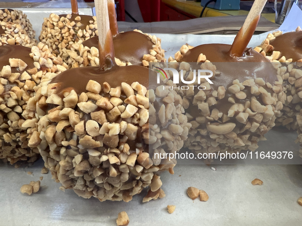 Caramel candy apples are covered with nuts at a carnival in Markham, Ontario, Canada, on October 5, 2024. 