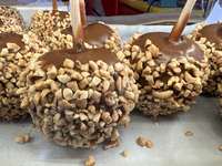 Caramel candy apples are covered with nuts at a carnival in Markham, Ontario, Canada, on October 5, 2024. (