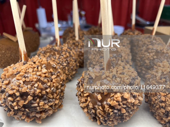 Caramel candy apples are covered with chocolate fudge and nuts at a carnival in Markham, Ontario, Canada, on October 5, 2024. 