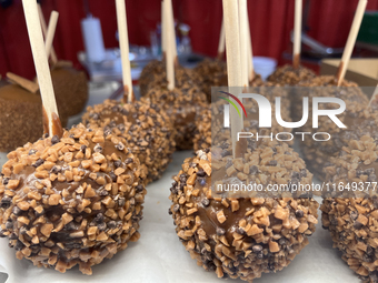 Caramel candy apples are covered with chocolate fudge and nuts at a carnival in Markham, Ontario, Canada, on October 5, 2024. (