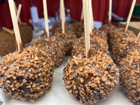 Caramel candy apples are covered with chocolate fudge and nuts at a carnival in Markham, Ontario, Canada, on October 5, 2024. (