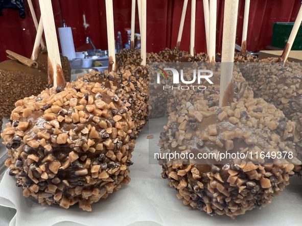 Caramel candy apples are covered with chocolate fudge and nuts at a carnival in Markham, Ontario, Canada, on October 5, 2024. 