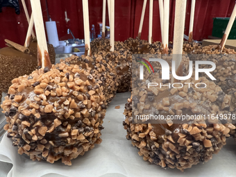 Caramel candy apples are covered with chocolate fudge and nuts at a carnival in Markham, Ontario, Canada, on October 5, 2024. (