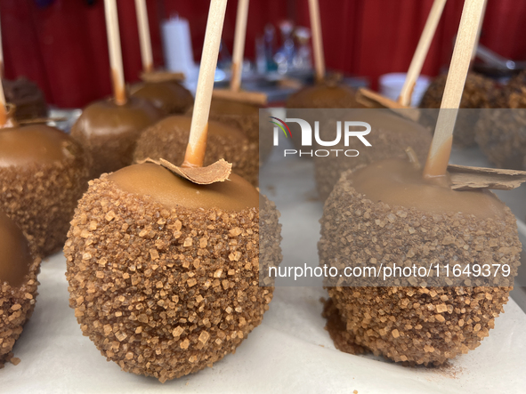 Caramel candy apples are covered with chocolate and sugar at a carnival in Markham, Ontario, Canada, on October 5, 2024. 