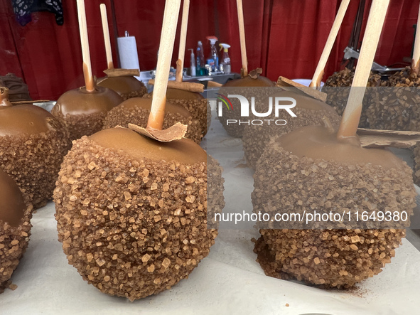 Caramel candy apples are covered with chocolate and sugar at a carnival in Markham, Ontario, Canada, on October 5, 2024. 