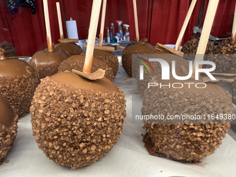 Caramel candy apples are covered with chocolate and sugar at a carnival in Markham, Ontario, Canada, on October 5, 2024. (