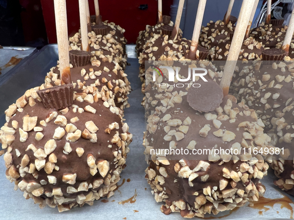 Caramel candy apples are covered with chocolate and nuts at a carnival in Markham, Ontario, Canada, on October 5, 2024. 