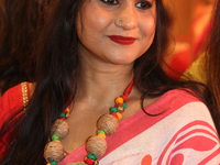 A Bengali Hindu woman wears a necklace with an image of the Goddess Durga while waiting to offer prayers during the Durga Puja festival at a...