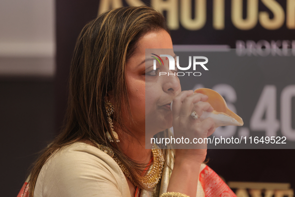 A woman blows a conch as prayers are recited during the Durga Puja festival at a pandal in Mississauga, Ontario, Canada, on October 06, 2024...