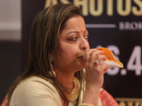 A woman blows a conch as prayers are recited during the Durga Puja festival at a pandal in Mississauga, Ontario, Canada, on October 06, 2024...