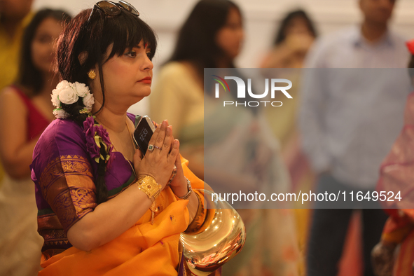 A Bengali Hindu woman offers prayers during the Durga Puja festival at a pandal (temporary temple) in Mississauga, Ontario, Canada, on Octob...