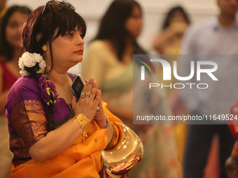 A Bengali Hindu woman offers prayers during the Durga Puja festival at a pandal (temporary temple) in Mississauga, Ontario, Canada, on Octob...