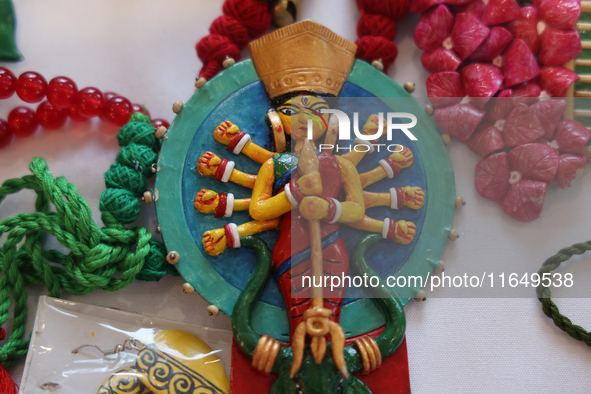 A necklace with a talisman featuring the Goddess Durga is for sale at a jewelry stall during the Durga Puja festival at a pandal (temporary...