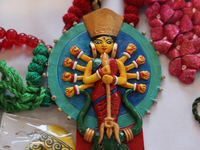 A necklace with a talisman featuring the Goddess Durga is for sale at a jewelry stall during the Durga Puja festival at a pandal (temporary...