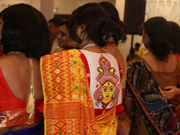 A Bengali Hindu woman wears a saree blouse (choli) with an image of the Goddess Durga during the Durga Puja festival at a pandal (temporary...